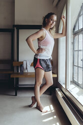 Portrait of confident woman standing in locker room - MFF04031