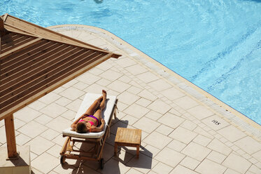 Woman relaxing in sun lounger at the poolside - ECPF00140