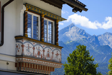 Deutschland, Oberbayern, Garmisch, Erker eines traditionellen Hauses mit Alpspitz-Massiv im Hintergrund - SIEF07545