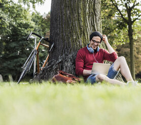 Man using laptop in park - UUF11747