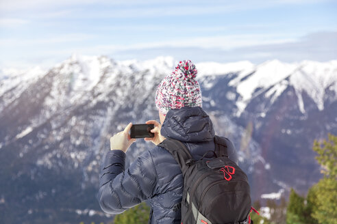 Deutschland, Bayern, Zugspitze, Rückenansicht eines Mannes, der ein Foto mit seinem Smartphone macht - MMAF00144