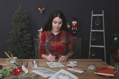 Junge Frau malt Weihnachtskarte mit Wasserfarben - RTBF01019