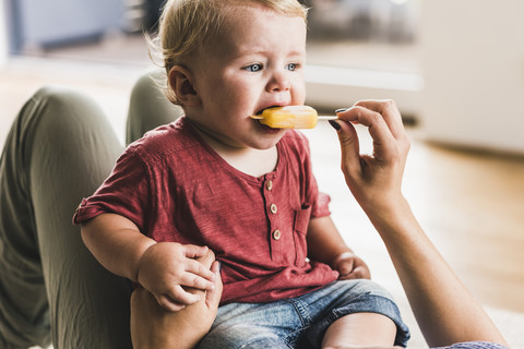 Mutter und Sohn essen zu Hause einen Eislutscher, lizenzfreies Stockfoto