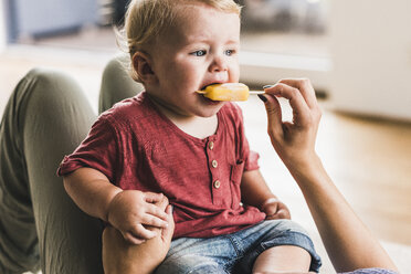 Mother and son at home eating ice lolly - UUF11786