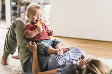 Mother and son at home eating ice lolly - UUF11788