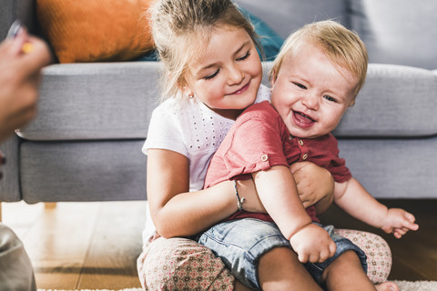 Bruder und Schwester zu Hause im Wohnzimmer, lizenzfreies Stockfoto