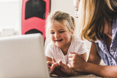 Mother and daughter having fun, using laptop - UUF11801