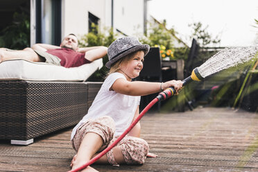 Little girl playing with garden hose - UUF11828