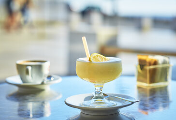 Italien, ein Glas Zitronengranita und eine Tasse Cappuccino im Hintergrund - DIKF00278