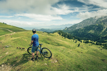 Germany, Bavaria, Pfronten, man with mountain bike on alpine meadow near Aggenstein - PNPF00027