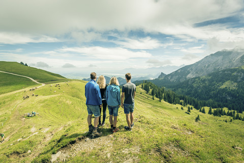 Deutschland, Bayern, Pfronten, Familie genießt die Aussicht auf einer Almwiese bei Aggenstein, lizenzfreies Stockfoto