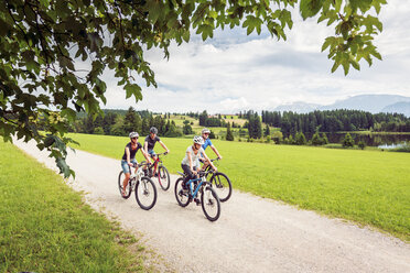 Germany, Bavaria, Pfronten, family riding mountain bikes at ladeside - PNPF00037