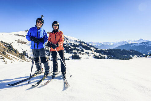 Austria, Damuels, couple with action cam skiing in winter landscape - PNPF00046