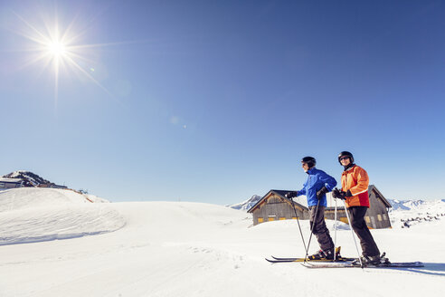 Österreich, Damuels, Paar mit Skifahrern in Winterlandschaft - PNPF00054