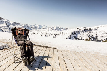 Österreich, Damuels, Frau entspannt im Liegestuhl auf Sonnendeck in Winterlandschaft - PNPF00056