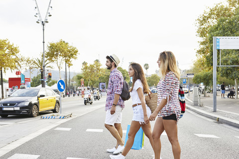 Drei Freunde überqueren eine Straße, lizenzfreies Stockfoto