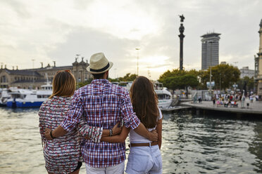 Spanien, Barcelona, drei Touristen umarmen sich am Wasser in der Stadt - JRFF01470