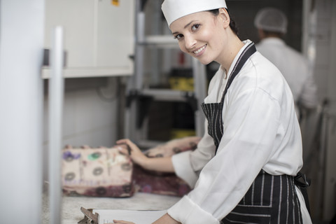 Porträt einer lächelnden Frau in einer Metzgerei, lizenzfreies Stockfoto