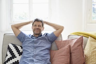 Mann sitzt zu Hause auf der Couch und entspannt sich - PDF01307