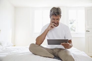 Porträt eines reifen Mannes mit digitalem Tablet im Schlafzimmer - PDF01368