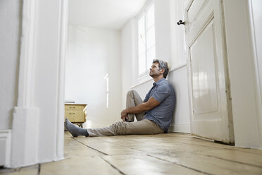 Älterer Mann sitzt auf dem Boden seines Schlafzimmers und träumt - PDF01375