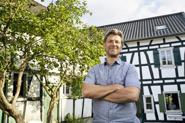 Mature man standing in his garden wearing apron - PDF01390