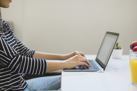 Junge Frau benutzt Laptop zu Hause, Teilansicht, lizenzfreies Stockfoto