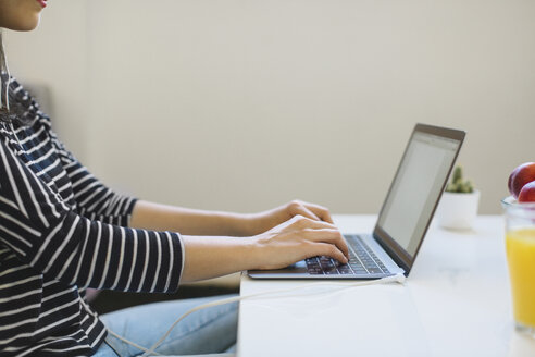 Junge Frau benutzt Laptop zu Hause, Teilansicht - MOMF00251