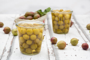 Jar of preserved gooseberries and gooseberries on wood - LVF06293