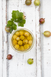 Jar of preserved gooseberries and gooseberries on wood - LVF06295