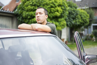 Portrait of serious man leaning on car roof - MOEF00147