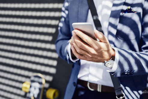 Close-up of businessman holding phone outdoors - BSZF00007