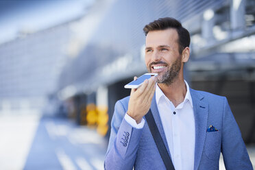 Smiling businessman talking on the phone outdoors - BSZF00014