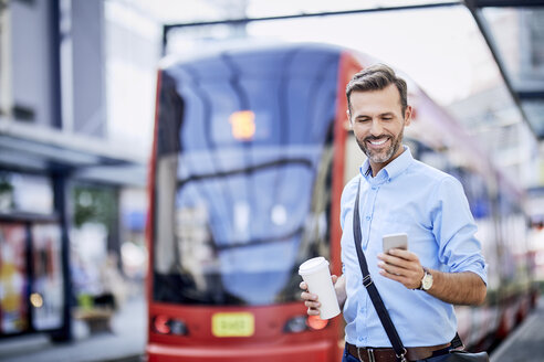 Geschäftsmann telefoniert nach dem Aussteigen aus öffentlichen Verkehrsmitteln - BSZF00035