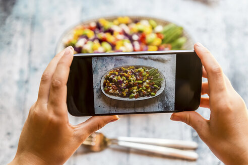 Mädchen fotografiert Quinoa-Salat mit Smartphone, Nahaufnahme - SARF03375
