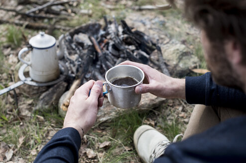 Mann trinkt Kaffee am Lagerfeuer - ZOCF00514