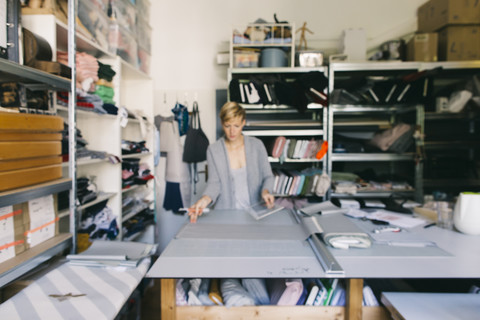 Modedesigner bei der Arbeit an einer Vorlage im Atelier, lizenzfreies Stockfoto
