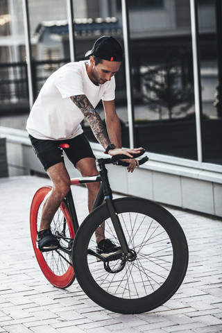 Junger Mann auf Fixie-Fahrrad in der Stadt, lizenzfreies Stockfoto