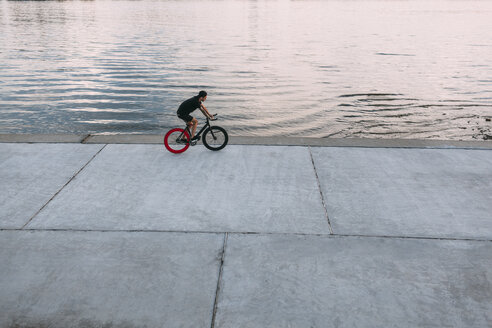 Junger Mann fährt Fixie-Bike am Wasser - VPIF00194