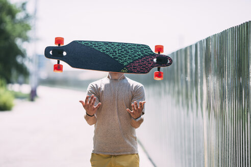 Unsichtbarer junger Mann wirft Longboard in die Luft - VPIF00223