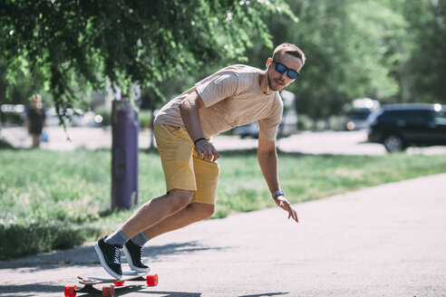 Junger Mann fährt Skateboard auf der Straße - VPIF00229