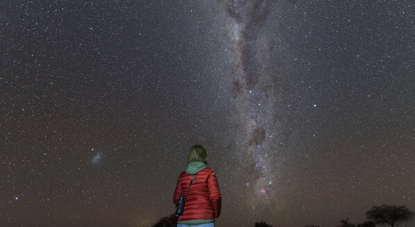Namibia, Region Khomas, bei Uhlenhorst, Astrofoto, Sternenguckerin beobachtet das Kreuz des Südens eingebettet in das Band der Milchstraße - THGF00005