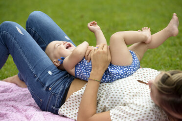Mother playing with her baby girl in a park - LBF01662