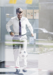 Geschäftsmann spielt Fußball im Büro - UUF11849