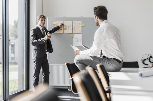 Zwei Kollegen arbeiten an einem Projekt im Büro - UUF11851