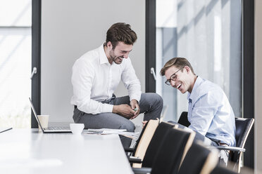 Zwei lachende Kollegen im Büro - UUF11866