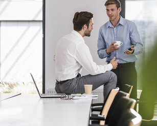 Zwei Kollegen arbeiten gemeinsam an einem Projekt im Büro - UUF11867