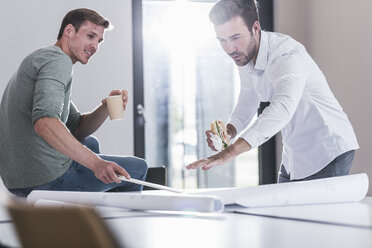 Zwei Kollegen arbeiten gemeinsam an einem Projekt im Büro - UUF11871