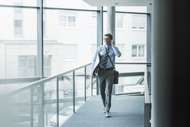 Glücklicher Geschäftsmann mit Surfbrett im Büro - UUF11881