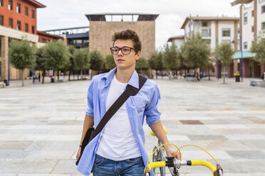Porträt eines jungen Mannes, der sein Fahrrad schiebt - MGIF00146